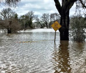 Flooded street and sign in Sonoma County on River Road