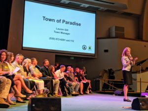 Paradise Town Manager Lauren Gill standing on stage making presentation
