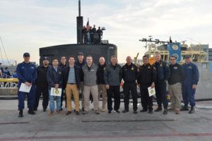 Cal OES and partners standing on pier in front of submarine