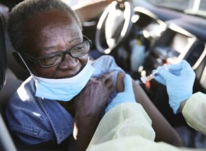 woman getting a vaccination shot in her car